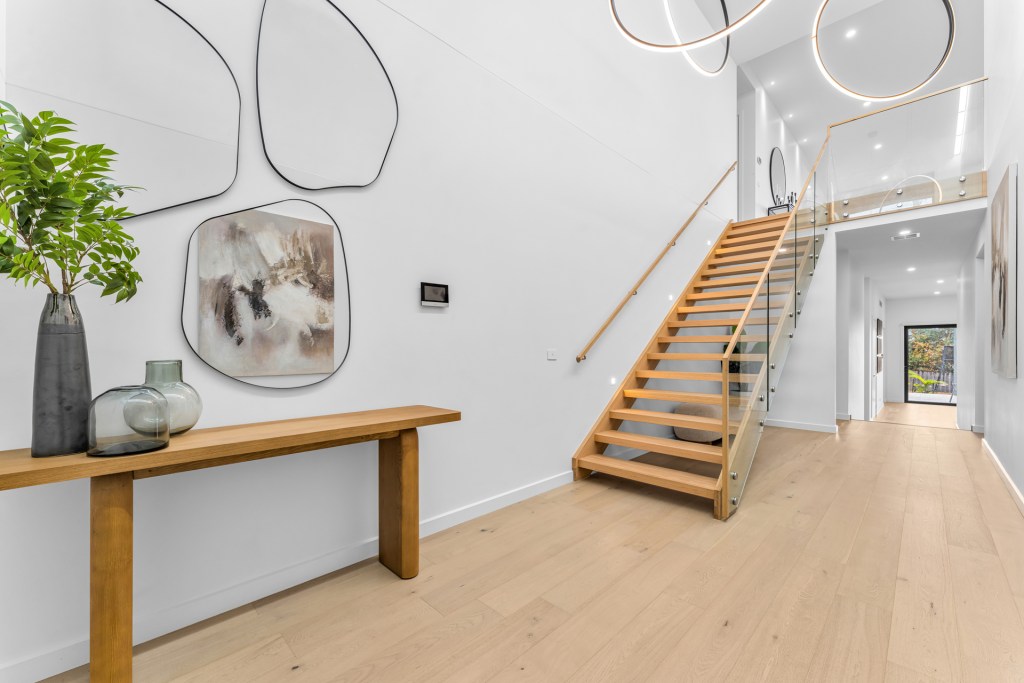 Mount Martha custom 2 storey home build with timber floorboard, timber staircase with glass balustrade, high ceilings with feature LED pendant lights